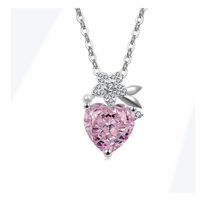 Close-up of pink heart-shaped crystal necklace with silver flower and pearl detail