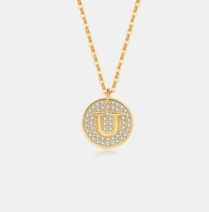 Close-up van een gouden s925 zilveren ketting met een sprankelende letter U hanger met diamanten