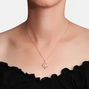 Detail van elegante gouden druppelhanger met witte parel en kristallen op een model