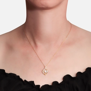 Elegante gouden ketting met een witte parel en zirkonia gedragen door een model