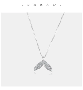 Macro detail of silver fishtail pendant necklace with shimmering white zircon stones