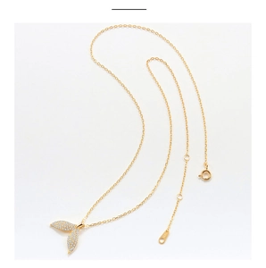Detail shot of gold fishtail necklace pendant with micro-paved cubic zirconia stones