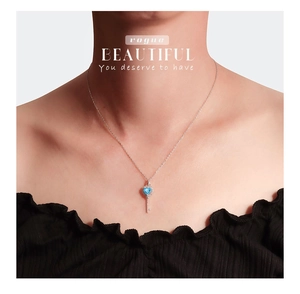 Detail van hartvormige sleutel hanger met hemelsblauwe steen en zilveren ketting