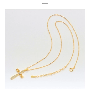Macro shot of S925 sterling silver stamp on golden cross necklace with crystal details