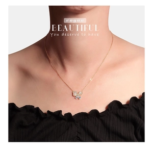 Close-up van gouden vlinderketting met gezette zirkonia kristallen bij een model