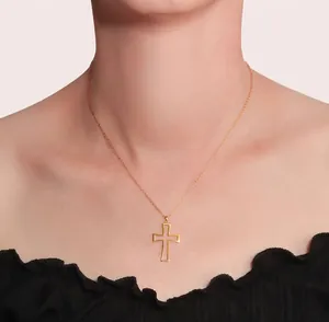 Close-up of a 925 sterling silver gold-plated cross necklace on a female neck