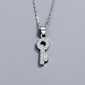 Macro shot of silver S925 necklace featuring a pavé-set key pendant on a fine link chain
