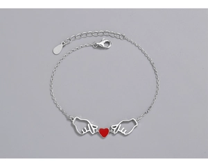 Detail view of S925 silver bracelet with heart gestures and red heart charm accent