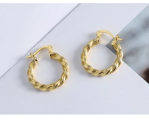 Detailed view of S925 engraved hallmark on golden twisted rope hoop earrings