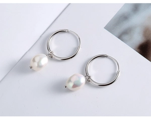 Detail of silver S925 hoop earrings featuring elegant white baroque freshwater pearls