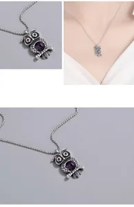 Makrodetail eines Retro-Eulenanhängers mit lila Edelstein und strukturierter Silberoberfläche