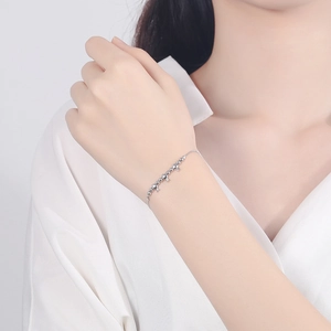 Minimalistisches S925 Sterlingsilber Armband mit Sternanhängern auf weißem Seidenhintergrund