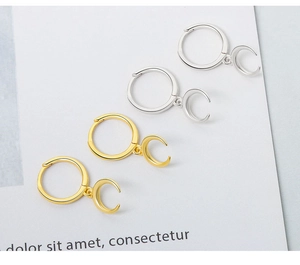Detail of elegant S925 sterling silver moon crescent drop earrings in gold and silver