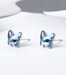 Macro detail of butterfly crystal stud earrings in S925 sterling silver with blue facets