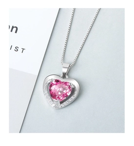 Detailed macro view of heart-shaped pink crystal pendant necklace with silver chain
