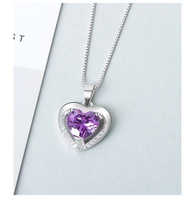 Close-up of heart-shaped purple gemstone necklace with white zircon pavé on silver chain