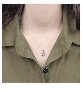 Detalle del collar de plata de ley 925 con colgante de circón azul en el cuello de modelo