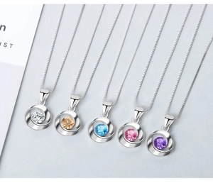 Detalle de cinco colgantes de circón coloridos en cadenas box de plata alineados con esmero