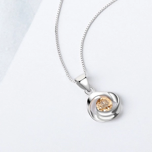 Elegante collar de plata de ley 925 con colgante de circón champán sobre fondo blanco