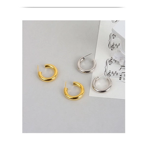 Detailansicht minimalistischer C-Form Creolen in poliertem Gold und Silberglanz