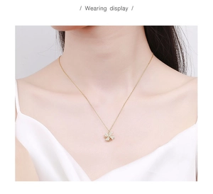 Wearing display of a gold rotating windmill necklace with zircon pavé pendant for women