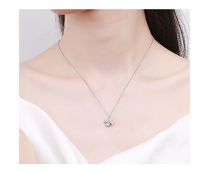 Close-up of a silver windmill four-leaf clover pendant on a model's neck