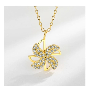 Close-up of a rotating windmill pendant with sparkling diamonds on a gold chain