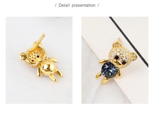 Detail view of gold-plated bear stud earrings with blue crystal and pave-set rhinestones