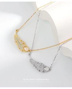 Macro shot of silver feather pendants with pavé zircon stones and opal teardrops