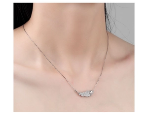 Close-up of S925 sterling silver leaf pendant with sparkling zircon and a pearl accent