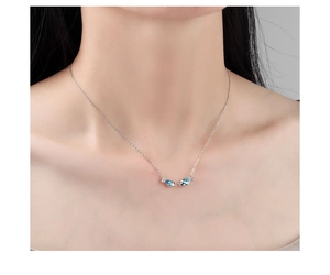 Close-up of S925 silver necklace featuring two blue crystal kissing fish pendants