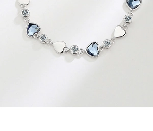 Close-up of heart-shaped blue crystal and polished silver links on elegant bracelet