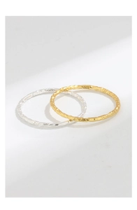 Macro detail of gold and silver S925 rings featuring a unique hammered foil texture finish