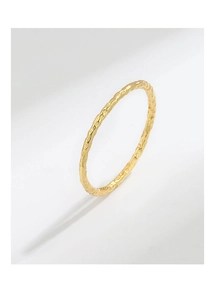 Close-up of a minimalist gold ring with a unique hammered tin foil texture finish