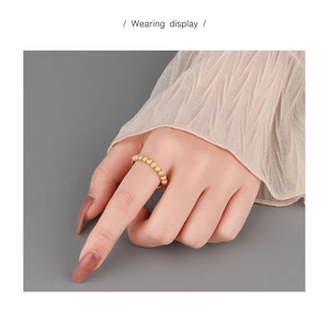 Wearing display of a gold S925 sterling silver beaded anxiety ring with matte texture