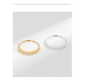 Close-up of S925 sterling silver spinning beads on gold and silver anxiety rings