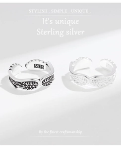 Close-up of S925 sterling silver angel wing rings with vintage oxidized and polished finishes