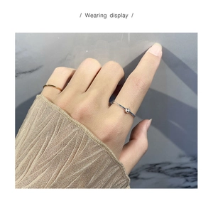 Detail of minimalist S925 sterling silver thin ring set on hand with beige knit cuff