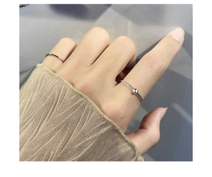 Detail showing minimalist 925 silver rings with smooth finish and metal bead on model