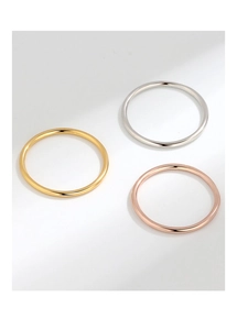 Detailed close-up of three polished minimalist rings in gold, silver, and rose gold finishes