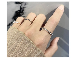 Dettaglio del set di anelli in argento S925 con perle sulla mano, design minimalista