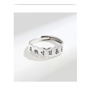 Macro detail of S925 sterling silver ring with scalloped edges and black mantra engraving