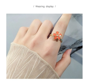 Wearing display of the orange enamel flower spinning ring with a center crystal