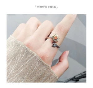 Gros plan d'une bague tournante tournesol en argent S925 sur le doigt d'un mannequin