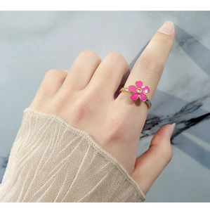 Detail of S925 silver spinning ring with pink enamel flower and center diamond