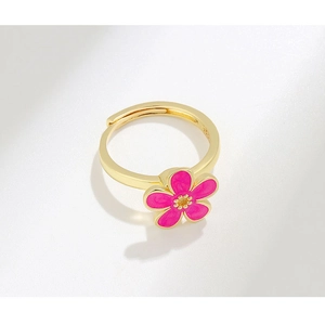 Close-up of S925 sterling silver stamp on golden flower ring with pink enamel petals