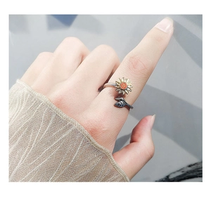 Vue macro d'une bague fidget tournesol en argent S925 avec pétales dorés sur un doigt