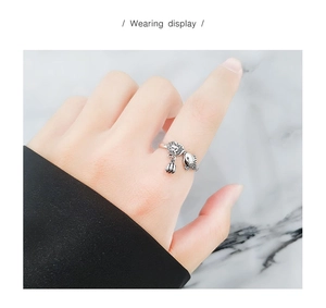 Detail of vintage S925 silver koi fish and lotus pod tassel ring worn on finger