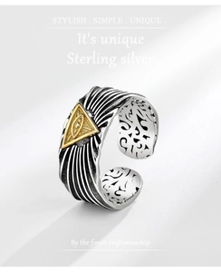 Macro detail of sterling silver ring featuring golden all-seeing eye with mystical engraving