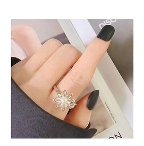 S925 Silberring mit rotierender Blüte, Perle und Diamantdetail an der Frauenhand